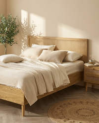 Lit ELARA en cannage rotin avec parure ivoire, ambiance matinale cosy - StudioSoie
